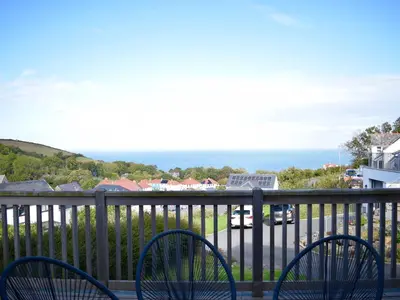a balcony with chairs and a view of the ocean at Ty Ni in New Quay