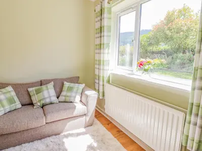 a living room with a couch and a window at Cam O'r Fechan Annexe in Llangollen