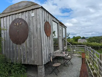 a wooden outhouse with a chair and a bench at Top of the Rock Glamping in Trefeglwys