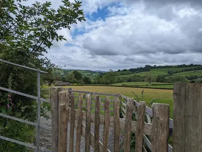 a wooden fence with a field in the background at Top of the Rock Glamping in Trefeglwys