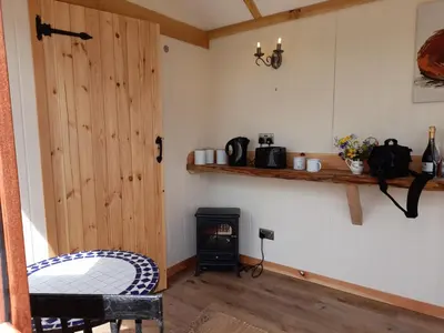 a room with a wood burning stove and a door at Top of the Rock Glamping in Trefeglwys