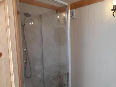 a shower with a glass door in a bathroom at Top of the Rock Glamping in Trefeglwys