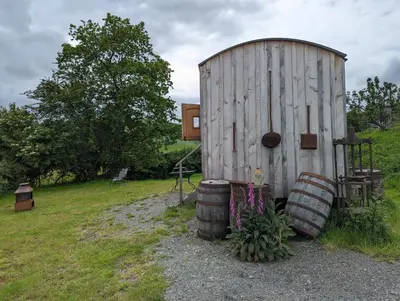 a wooden shed with two barrels next to it at Top of the Rock Glamping in Trefeglwys