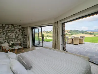 a bedroom with a bed and a large window at Llety Cariad in Montgomery