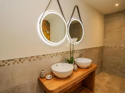 a bathroom with two sinks and two mirrors at Llety Cariad in Montgomery