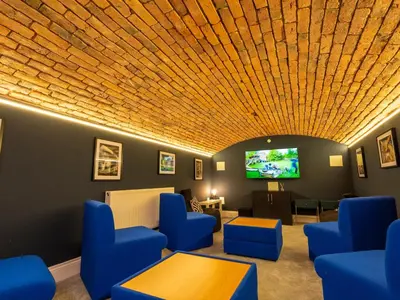 a waiting room with blue chairs and a flat screen tv at Old Rectory House in Newtown