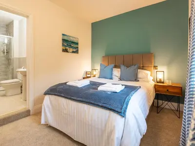 a bedroom with a large bed and a bathroom at Old Rectory House in Newtown
