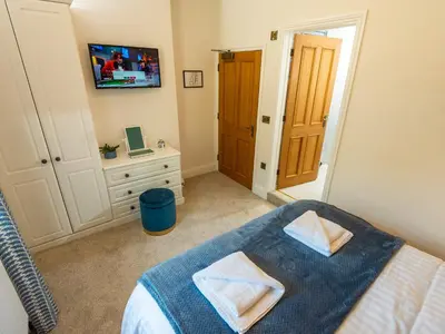 a bedroom with a bed and a desk and a television at Old Rectory House in Newtown