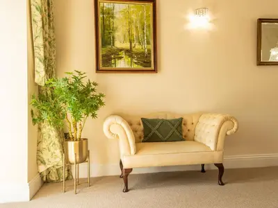 a living room with a couch with a pillow on it at Old Rectory House in Newtown