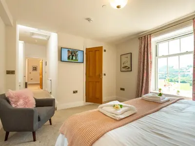 a bedroom with a bed and a chair and a window at Old Rectory House in Newtown