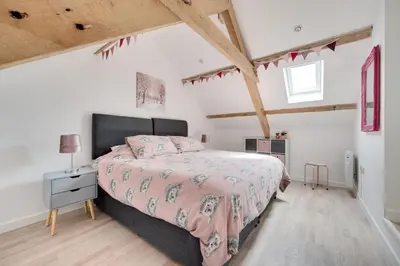 a bedroom with a large bed and a wooden floor at 4 Bed in Aberystwyth oc-bow304 in Rhostie
