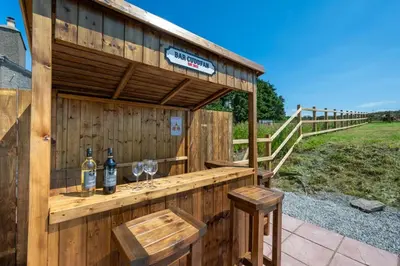 a wooden bar with two glasses of wine at 4 Bed in Aberystwyth oc-bow304 in Rhostie