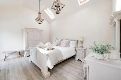 a white bedroom with a white bed and a table at 3 Bed in Trawsfynydd oc-wag718 in Trawsfynydd
