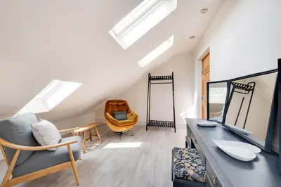 a living room with a skylight and a chair at 3 Bed in Trawsfynydd oc-wag718 in Trawsfynydd