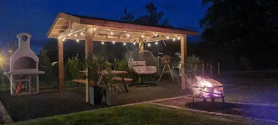 a gazebo with a table and chairs in a yard at night at EASTRIDGE GLAMPING in Shrewsbury