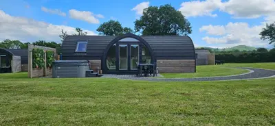 a small cabin in the middle of a grass field at EASTRIDGE GLAMPING in Shrewsbury