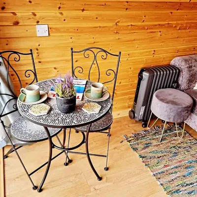 a table and chairs in a living room with a table and chairs at Forester's Retreat Glamping - Dinas View - Vaccinated dogs over the age of 2 are accepted in Aberystwyth