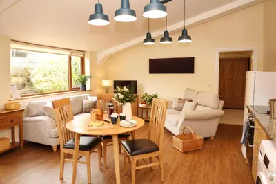a kitchen and living room with a table and chairs at Great Western Lodge at Eaton Manor in Eaton