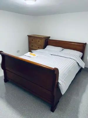 a bed with a wooden frame and a dresser in a room at 21 ,North Street in Shrewsbury