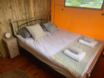a bed with two pillows on top of it at Mountain View Safari Tent with Hot Tub in The Heart of Snowdonia in Dolgellau