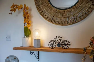 a bike on a wooden shelf with a lamp at Apple Tree Cottage - Cosy 2 Bed with Deluxe HOT TUB & Log Burner in Hereford