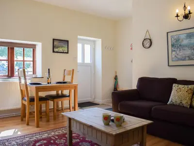 a living room with a couch and a table at Dairy Cottage in Talley
