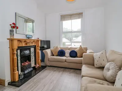 a living room with a couch and a fireplace at 4 Tanyrallt Terrace in Llangollen