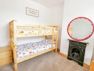 a bedroom with two bunk beds and a mirror at 4 Tanyrallt Terrace in Llangollen