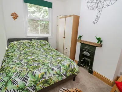 a bedroom with a bed and a fireplace at 4 Tanyrallt Terrace in Llangollen