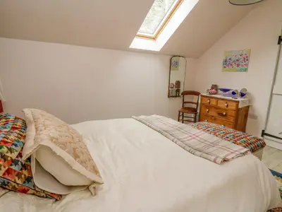 a bedroom with a bed and a dresser and a window at Buzzards Breg in Builth Wells