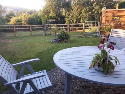 a picnic table with two chairs and a table with flowers on it at Buzzards Breg in Builth Wells