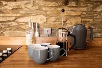 a row of coffee cups on a counter with a blender at Hay Barn, Penrheol Farm, Unique Barn Conversion in Builth Wells