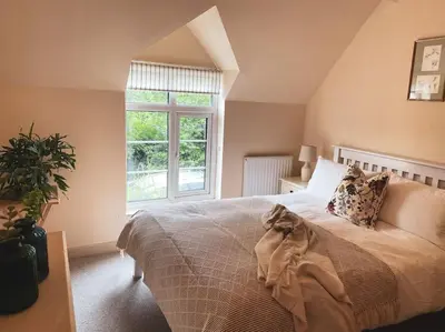 a bedroom with a large bed and a window at Boutique country hideaway ‘Jacks Cottage’ in Diddlebury
