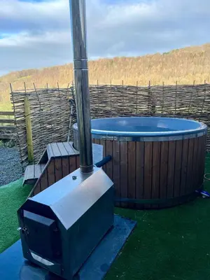 a hot tub with a tv in front of it at Cader Mountain View Cottage with Hot Tub in Snowdonia in Dolgellau
