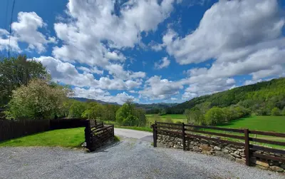 a fence on a road next to a field at Cader Mountain View Cottage with Hot Tub in Snowdonia in Dolgellau