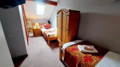 a small bedroom with a bed and a dresser at Cader Mountain View Cottage with Hot Tub in Snowdonia in Dolgellau