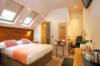 a bedroom with a bed and a desk in a room at Castle Hotel in Aberystwyth