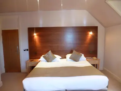 a bedroom with a large bed with a wooden headboard at Castle Hotel in Aberystwyth