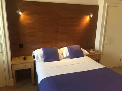 a bedroom with a bed and a wooden headboard at Castle Hotel in Aberystwyth