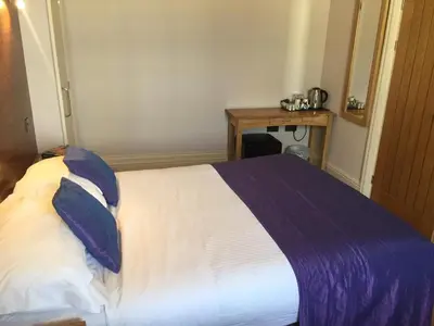 a bedroom with a bed with a blue and white blanket at Castle Hotel in Aberystwyth