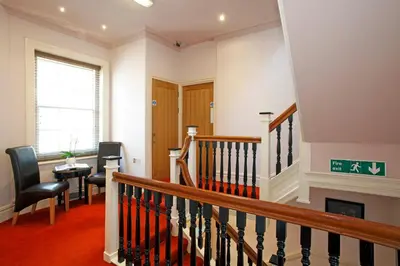 a room with a staircase with a table and chairs at Castle Hotel in Aberystwyth