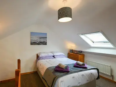 a bedroom with a bed and a window at Maldwyn in Tywyn