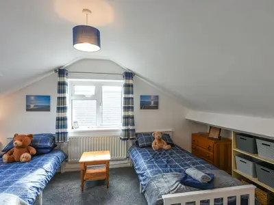 two beds in a bedroom with two teddy bears at Maldwyn in Tywyn