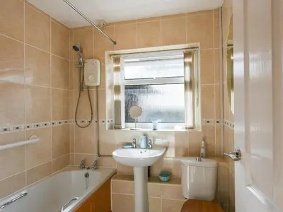 a bathroom with a sink and a tub and a toilet at Maldwyn in Tywyn