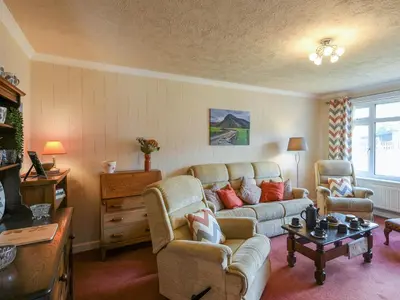 a living room with a couch and chairs and a table at Maldwyn in Tywyn