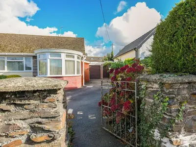 a gate to a house with flowers on it at Maldwyn in Tywyn