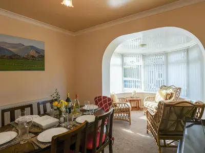 a dining room with a table and some chairs at Maldwyn in Tywyn