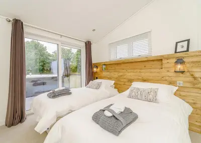 two beds in a room with a window at Winston Farm Lodges in Ternhill