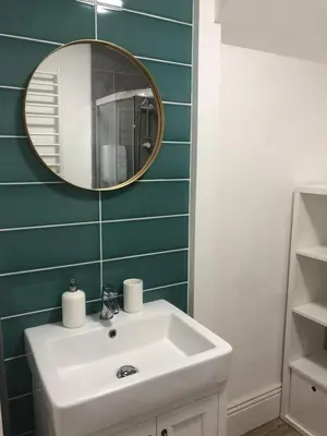 a bathroom with a white sink and a mirror at Lovely Seafront 2 bed flat in Aberystwyth in Aberystwyth
