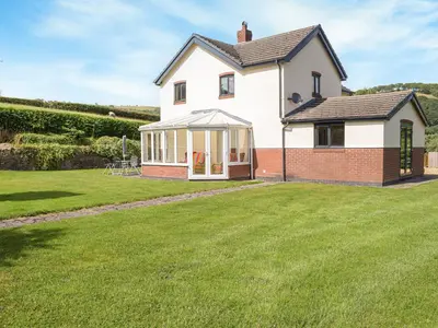 a house with a lawn in front of it at Hill View Lodge in Knucklas